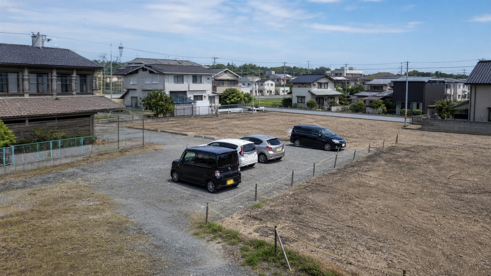 高所に設置したソーラー監視カメラで駐車場と空き地を見渡すイメージ